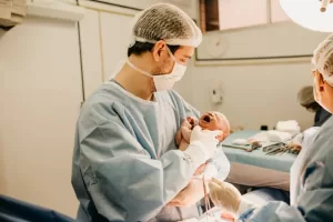 Childbirth - pic of man in scrubs holding a baby